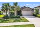 One-story house with gray siding, two-car garage, and palm trees at 2529 Sherman Oak Dr, North Port, FL 34289