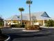 Community clubhouse with metal roof, landscaping, and ample parking at 25533 Heritage Lake Blvd # 19, Punta Gorda, FL 33983