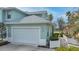 Exterior view of charming teal home with white garage door at 25533 Heritage Lake Blvd # 19, Punta Gorda, FL 33983