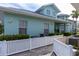 Side view of house showcasing teal exterior and white fence at 25533 Heritage Lake Blvd # 19, Punta Gorda, FL 33983