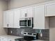 Close-up of kitchen, white cabinets, stainless steel microwave at 3733 Basket St, North Port, FL 34288