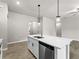 Kitchen island with sink, dishwasher, and white cabinetry at 3733 Basket St, North Port, FL 34288