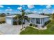 Light blue single-story house with a metal roof, paver driveway, and landscaped yard at 3845 Bal Harbor Blvd, Punta Gorda, FL 33950