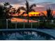 Stunning sunset view from a backyard pool with a cable railing and landscape at 3845 Bal Harbor Blvd, Punta Gorda, FL 33950