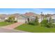 House exterior showcasing a green facade, brick pavers, and lush landscaping at 3861 Cobblestone Ln, Port Charlotte, FL 33980