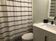 Clean bathroom with white vanity and striped shower curtain at 4158 Tamiami Trl # B3, Port Charlotte, FL 33952