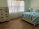 Bright bedroom with hardwood floors and striped bedding at 4158 Tamiami Trl # B3, Port Charlotte, FL 33952