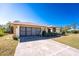 Front exterior showcasing the two car garage, driveway and clean landscaping at 5991 Gillot Blvd, Port Charlotte, FL 33981