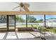 Enclosed lanai features ceiling fan and tile flooring and a view of the back yard at 5991 Gillot Blvd, Port Charlotte, FL 33981