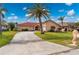 Beautiful one-story home with red tile roof, palm trees, and a large driveway at 674 Monaco Dr, Punta Gorda, FL 33950