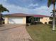 Front view of a house with a red tile roof and a brick paved driveway at 721 Brenda Ct, Punta Gorda, FL 33950