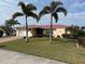 Single-story home with a red tile roof, white garage door, and palm trees at 721 Brenda Ct, Punta Gorda, FL 33950