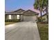 Tan house exterior with two-car garage at dusk at 7249 W Lenox Cir, Punta Gorda, FL 33950