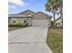 Tan house exterior with a two-car garage and landscaping at 7249 W Lenox Cir, Punta Gorda, FL 33950