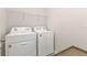 Bright laundry room with washer, dryer, and shelving at 7249 W Lenox Cir, Punta Gorda, FL 33950