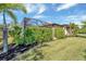 Landscaped backyard with lush greenery and screened enclosure at 1041 Harbour Park Ct, Punta Gorda, FL 33983