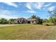 Front view of a tan house with a three-car garage at 1041 Harbour Park Ct, Punta Gorda, FL 33983