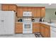 White appliances and light wood cabinets in kitchen at 1246 Rio De Janeiro Ave # 509, Punta Gorda, FL 33983