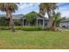 Bright gray house with a screened porch and palm trees at 1259 Red Oak Ln, Port Charlotte, FL 33948