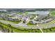 Aerial view of the clubhouse and pool, surrounded by a parking lot, golf course, lake, and community landscaping at 15950 Grassland Ln # 2622, Punta Gorda, FL 33982