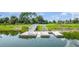 A close-up of a modern dock on a tranquil pond, surrounded by verdant greenery and a picturesque landscape at 15950 Grassland Ln # 2622, Punta Gorda, FL 33982