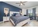 Main bedroom boasts a blue accent wall, ceiling fan, and water view from the window at 15950 Grassland Ln # 2622, Punta Gorda, FL 33982