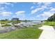 Scenic waterfront view with a dock, lush greenery, and a bright, sunny sky at 15950 Grassland Ln # 2622, Punta Gorda, FL 33982