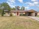 Ranch-style home with carport, spacious lawn, and red door at 168 Dartmouth Nw Dr, Port Charlotte, FL 33952