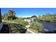 Private dock with covered boat lift and lush landscaping at 18042 Eau Gallie Cir, Port Charlotte, FL 33948