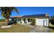 Attractive single-story home with solar panels and a palm tree at 18042 Eau Gallie Cir, Port Charlotte, FL 33948