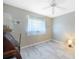 Bedroom with light gray walls, white wood-look floors, and ceiling fan at 18395 Edgewater Dr, Port Charlotte, FL 33948