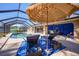 Inviting pool area with lounge chairs and a blue umbrella at 18395 Edgewater Dr, Port Charlotte, FL 33948