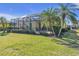 Landscaped backyard with a screened pool and lush tropical plants at 1848 Bobcat Trl, North Port, FL 34288