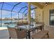 Relaxing screened patio with table and chairs, overlooking the pool and lake at 1848 Bobcat Trl, North Port, FL 34288