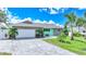 Inviting teal home with stone accents, a white garage door, and a landscaped front yard at 192 Danforth S Dr, Port Charlotte, FL 33980