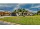 Single-story home with landscaped lawn, palm trees, and a two-car garage at 245 Brighton Ct, Englewood, FL 34223