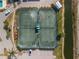 Two tennis courts with seating area and surrounding landscape at 25188 Marion Ave # E103, Punta Gorda, FL 33950