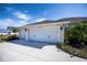 Three-car garage with white doors and carriage-style lighting at 269 Mariner Ln, Rotonda West, FL 33947