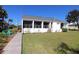 Backyard view showing screened porch, walkway, and grassy area at 3000 Peace River Dr, Punta Gorda, FL 33983