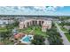 Aerial view highlighting condo building, pool, and lush landscaping at 3006 Caring Way # 331, Port Charlotte, FL 33952