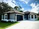 Modern home with gray exterior, two-car garage, and landscaping at 4393 Antioch St, North Port, FL 34288