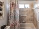 Bathroom with tub shower, window, and patterned curtain at 4398 Appleton Ter, North Port, FL 34286