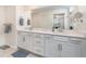 Bathroom with double sinks, white cabinets, and a large mirror at 43996 Boardwalk Loop # 1411, Punta Gorda, FL 33982