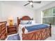 Comfortable bedroom with a wooden bed frame, blue accents, and a window with blinds at 43996 Boardwalk Loop # 1411, Punta Gorda, FL 33982