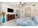 Well-lit bedroom features a ceiling fan, TV, blue and white bedding, and a spacious dresser at 43996 Boardwalk Loop # 1411, Punta Gorda, FL 33982