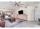 The open-plan living room with modern furniture, a ceiling fan, and tile flooring leads to the kitchen at 43996 Boardwalk Loop # 1411, Punta Gorda, FL 33982