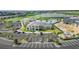 Aerial view of parking lot and community buildings with lush green golf course in background at 43996 Boardwalk Loop # 1411, Punta Gorda, FL 33982