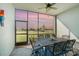 A covered outdoor dining area features decorative table and chairs with views of a sunset over the pond at 43996 Boardwalk Loop # 1411, Punta Gorda, FL 33982