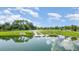 Scenic pond featuring a white bridge, lush greenery, and a clear reflection of the sky at 43996 Boardwalk Loop # 1411, Punta Gorda, FL 33982