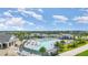 An aerial view of a community pool area with palm trees, lounge chairs, and a clear blue sky at 43996 Boardwalk Loop # 1411, Punta Gorda, FL 33982